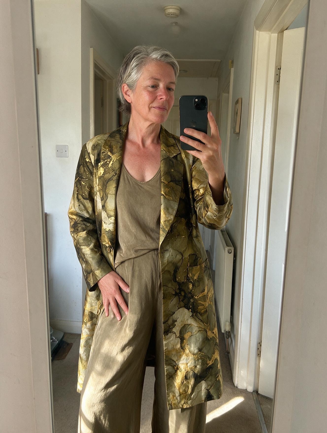 Customer in the olive and gold three-piece set, mirror selfie at home